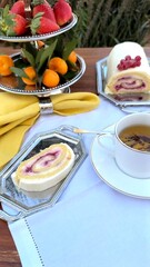 Cake roll placed beside cup on ornate silver tray, creamy cake swirls decorated with berries, elegant napkin folds creating timeless charm. Cup enhances vintage cake atmosphere. Nostalgic tea concept.