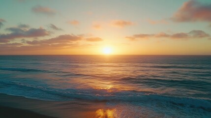 Obraz premium Stunning sunset over ocean waves on sandy beach.