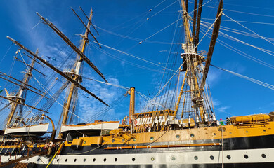 A large old ship at pier under a beautiful blue sky