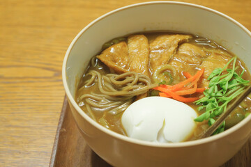 Japanese curry soba noodles topped with half-boiled egg and fried tofu, warm and spicy