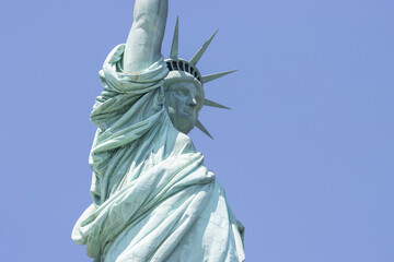 Closeup of the Statue of Liberty on the Liberty Island in New York against a clear blue sky.