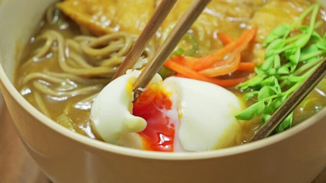Japanese curry soba noodles topped with half-boiled egg and fried tofu, warm and spicy