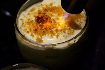 Prepare crème brulée, also known as burnt cream or Trinity cream. Caramelize the sugar layer with...
