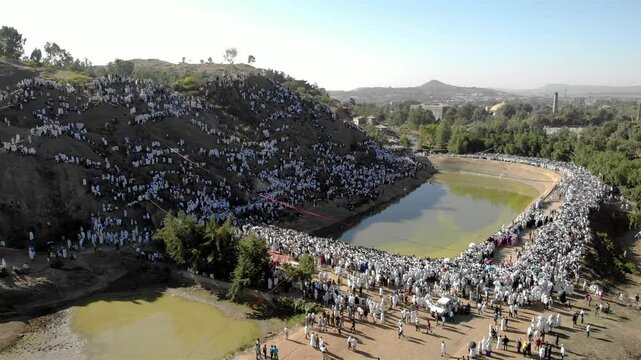 Thousands of Ethiopian people at Timkat parade- Aerial Footge 
Drone view over Large crowd parade dressed in white clothes Ethiopian Timkat Ceremony Ending, Ethiopia,19.1.2020
