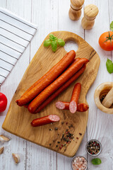 smoked sausages on a board with basil