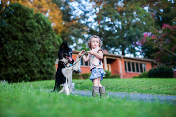 Fototapeta premium Girl holding her dogs hand
