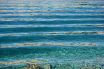Small waves gently roll over the blue sea