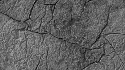 Cracked concrete wall covered with gray cement mortar. 