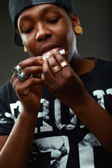 Young person rolling a cigarette containing dried tobacco