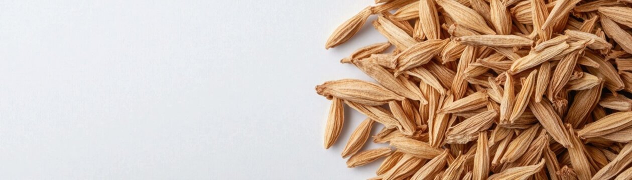 Close-up of cumin seeds scattered on a neutral background, showcasing their unique shape and texture.