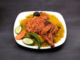 Alfahm grill fried chicken majboos rice in a white ceramic plate in a dark background