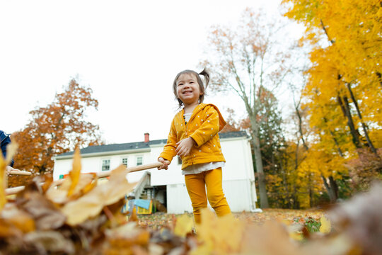 Low Angle of Smiling Adorable Girl in Backyard During Changing Season