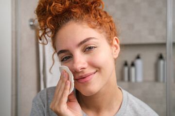 Woman using reusable makeup remover pad, sustainable beauty routine