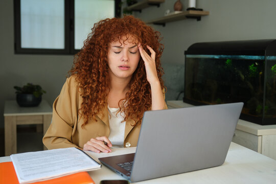 Tired businesswoman suffering from headache working from home office