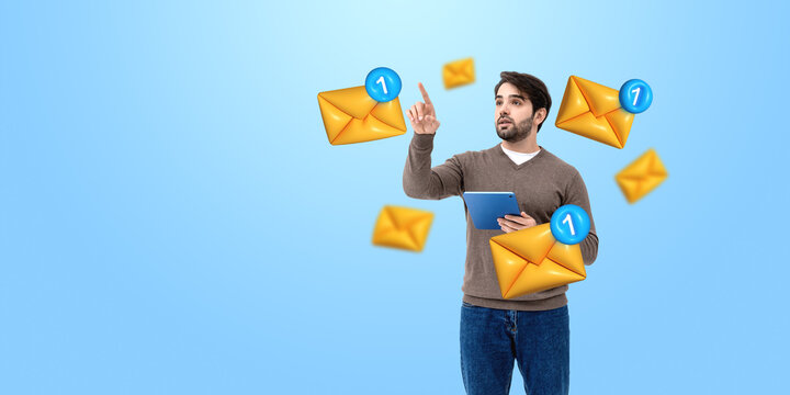 Man with tablet interacting with email icons on blue background.