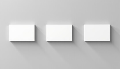 Naklejka premium Three blank business cards mockup on gray wall, minimalistic design, creative presentation, copy space