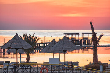 Fantastic sunrise in Marsa Alam over the Red Sea. visible palm trees, beach umbrellas, typical hotel buildings. Egypt, Marsa Alam 2024