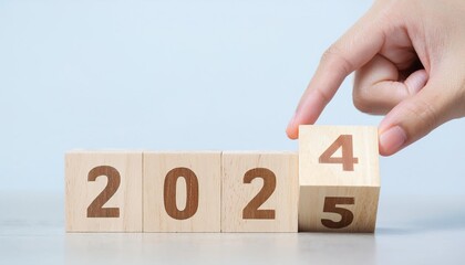 Hand Arranging Wooden Blocks to Show 2025: New Year, Future, Goals, and Planning Concept