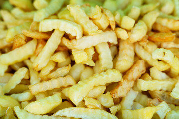 Crispy golden crinkle cut fries piled high on a vibrant background