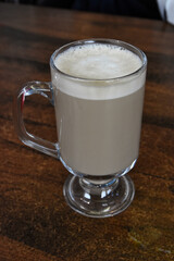 A mug with a handle containing hot coffee with milk