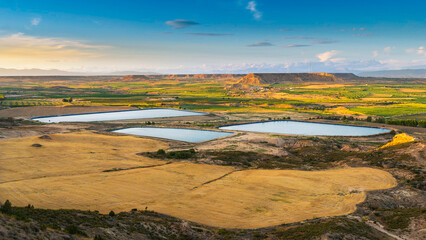 Irrigation ponds for crop fields and wind farm in the background