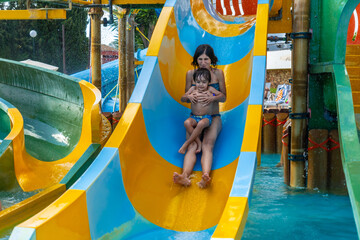 A woman and a child are sliding down a water slide
