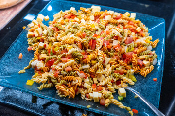 A plate of pasta with lots of vegetables and cheese