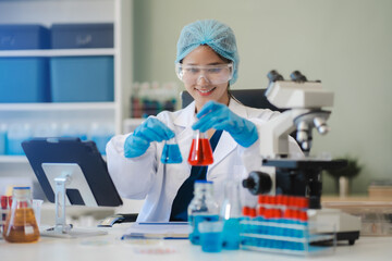 Chemist scientist holding test tube and tablet conducting experiment in laboratory with equipment,...