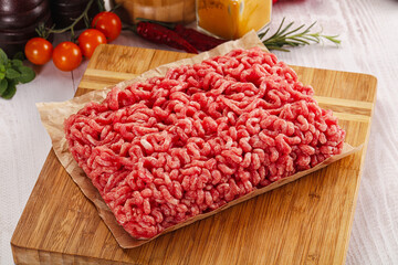 Raw minced beef meat over board