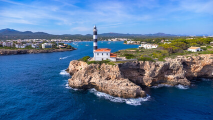 Portocolom lighthouse shining over mallorca coast on a sunny day