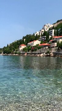 Croatia Dubrovnik. Swimming from the cliff. The stunning coastal scene features sparkling clear water along with charming homes dotted gracefully by the shoreline