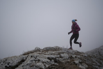 trail running woman athlete training for ultra-marathon race in a mountain