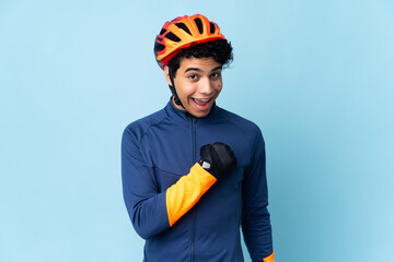 Venezuelan cyclist man isolated on blue background celebrating a victory