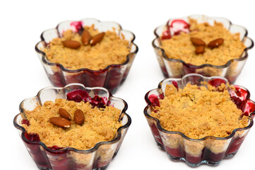 Delightful cherry crumble dessert served in elegant glass bowls garnished with roasted almonds