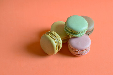Macarons stacked, isolated, on orange background and copy space.	