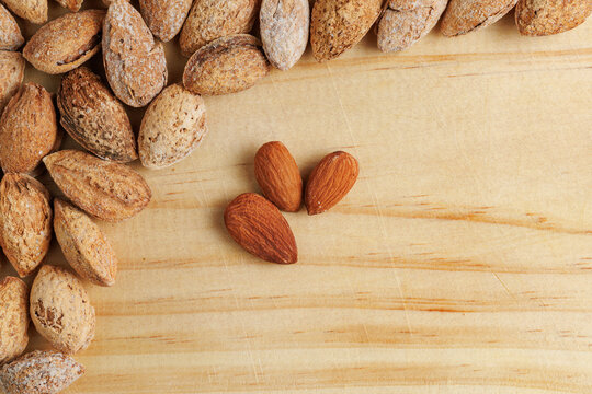 Grupo de almendras crudas con espacio negativo sobre tabla de madera