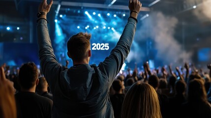 A man is holding his hands up in the air in front of a large crowd