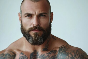 Portrait of serious bearded man showing tattoos and muscles