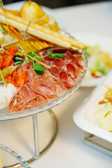 Plate with cheese, sausage and vegetables on a served festive table. catering for a holiday.