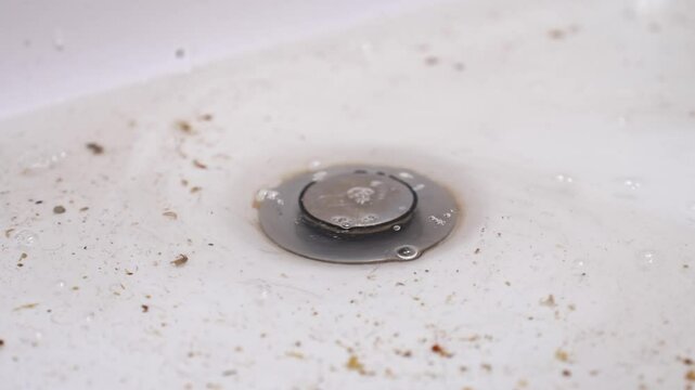 male hand cleans the sink from blockages. cleaning the drain from hair and debris in the bathroom.