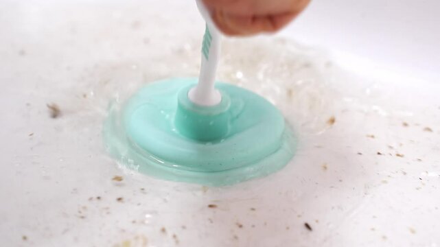 A small white and blue plunger cleans the sink from blockages. cleaning the drain from hair and debris in the bathroom.