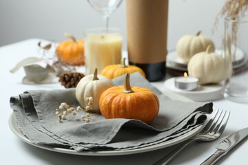 Rustic holiday table setup with plates, cutlery and autumn decorations