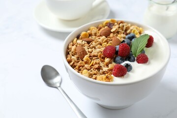 Delicious granola with berries and yogurt on a light background