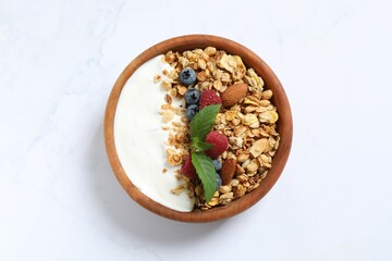 Delicious granola with berries and yogurt on a light background
