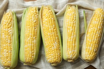 Fresh corn on cobs on marble background, top view