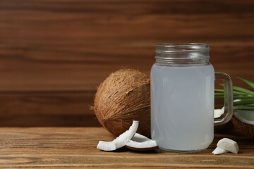 Mason jar with coconut water with nuts on wooden table