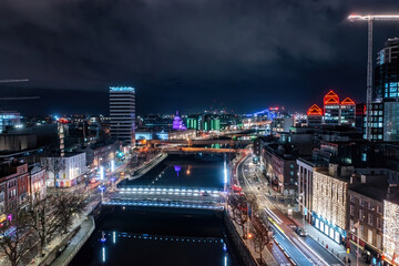Long exposure aerial shot of Dublin at night, highlighting the city's stunning architecture and festive winter lights. Aerial