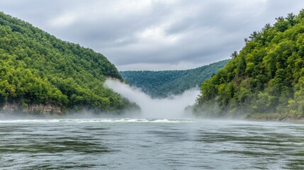 Misty river valley surrounded by lush green hills.