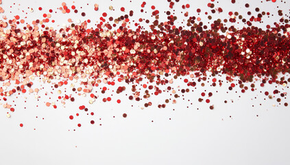 Obraz premium Red and gold glitter scattered on a white surface for festive decoration