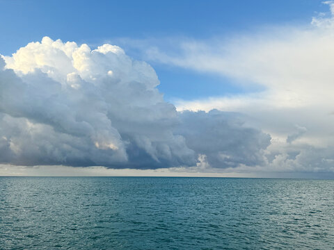 Puffy clouds over ocean water.